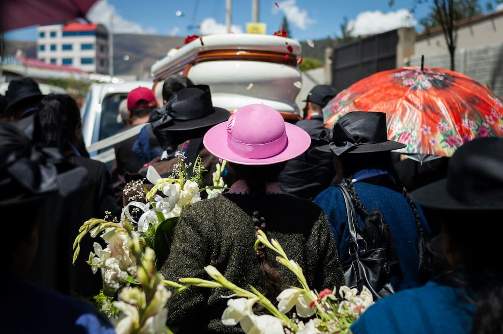 Sad family at a funeral standing by a grave with flowers in South Africa